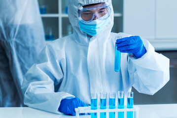Scientist man holding sample blood test tube in science laboratory. Doctor clinic healthcare...