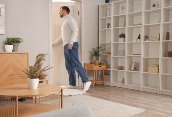 Young man opening door in living room