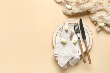 Beautiful table setting with Easter eggs and feather on beige background
