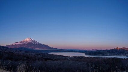 展望台から見た朝焼けに染まる富士山と山中湖のパノラマ情景