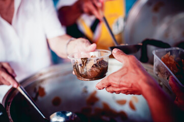 The hands of the poor apply for food from rich people who donate food.
