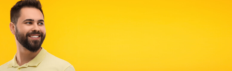 Naklejka premium Man with clean teeth smiling on yellow background, space for text. Banner design