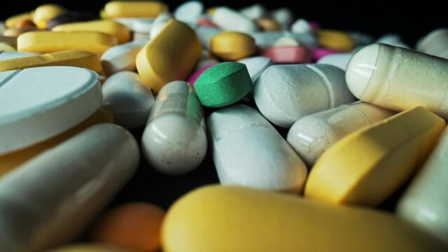 Multicolored capsules or vitamins, oral pills and side effects. Pharmaceutical industry, healthcare, drug use. Macro view.