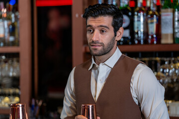 Man bartender is making a drink and dancing at bar. Dance party with group people dancing . Women and men have fun and drinking martini cocktail in night club.