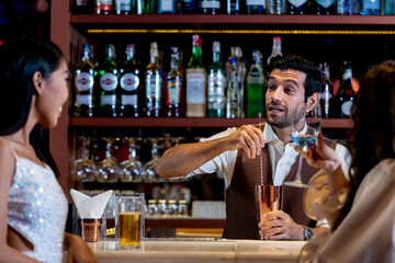 two girls in sexy dress are drinking and dancing at bar. Dance party with group people dancing . Women and men have fun and drinking martini cocktail in night club.