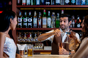 two girls in sexy dress are drinking and dancing at bar. Dance party with group people dancing . Women and men have fun and drinking martini cocktail in night club.