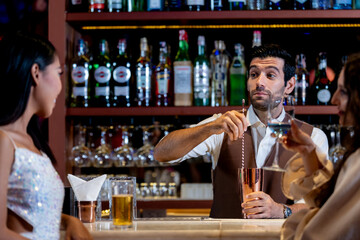 two girls in sexy dress are drinking and dancing at bar. Dance party with group people dancing . Women and men have fun and drinking martini cocktail in night club.