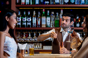 two girls in sexy dress are drinking and dancing at bar. Dance party with group people dancing . Women and men have fun and drinking martini cocktail in night club.