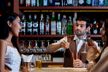 two girls in sexy dress are drinking and dancing at bar. Dance party with group people dancing . Women and men have fun and drinking martini cocktail in night club.