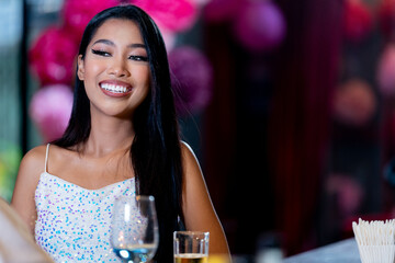 Thai girl in sexy dress are drinking and dancing at bar. Dance party with group people dancing . Women and men have fun and drinking martini cocktail in night club.