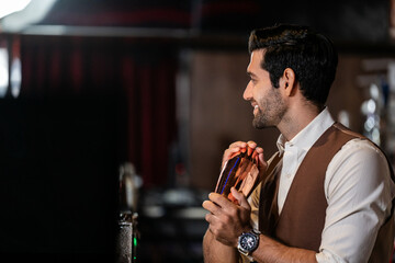 Man bartender is making a drink and dancing at bar. Dance party with group people dancing . Women and men have fun and drinking martini cocktail in night club.