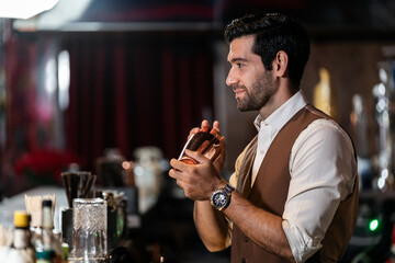 Man bartender is making a drink and dancing at bar. Dance party with group people dancing . Women and men have fun and drinking martini cocktail in night club.