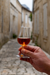 Tasting of cognac alcohol drink and view on old streets and houses in town Cognac, Grand Champagne,...