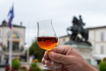 Tasting of cognac alcohol drink and view on old streets and houses in town Cognac, Grand Champagne,...