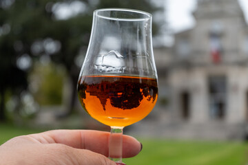 Tasting of cognac alcohol drink and view on old streets and houses in town Cognac, Grand Champagne, Charente, strong spirits distillation industry, France