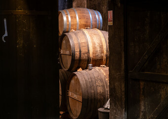Aging process of cognac spirit in old French oak barrels in cellar in distillery in Cognac white...