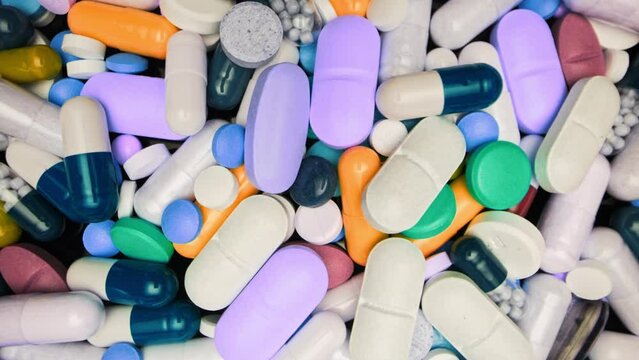 Multicolored capsules or vitamins, oral pills and side effects. Pharmaceutical industry, healthcare, drug use. Macro view.