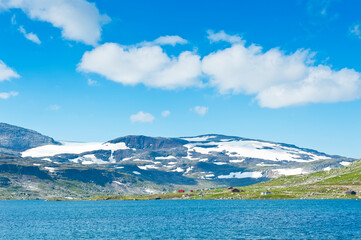 Beautiful landscape with Lake Finsevatnet, snowy mountains and glacier Hardangerjokulen in Finse, Norway - 750275841