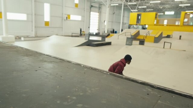 Young skater performing trick, skateboarder training in skatepark, making tricks, slides and flips, jump over the gap, professional extreme sport athlete ride on skateboard. 