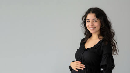 Hispanic pregnant woman with pregnancy belly, in soft black clothes