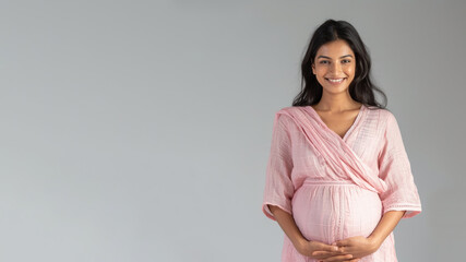 Indian pregnant woman with pregnancy belly, in soft pink clothes - obrazy, fototapety, plakaty