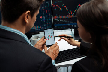 Focusing on phone with discussing dynamic stock market in two business traders online website...