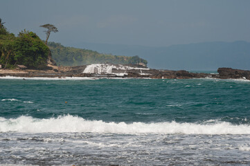 Rocas con olas y cascadas de Karang Taraje foto desde karang Beurem, Sawarna, Lebak Regency, Banten, Java,, Indonesia