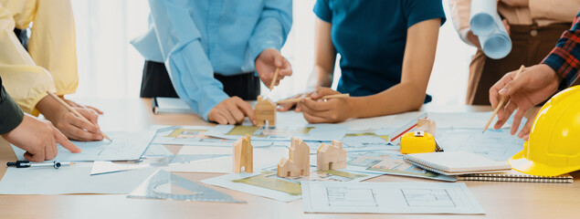 Professional architect team plans to build eco house at meeting table with green design document...