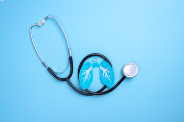 Lungs paper symbol and medical stethoscope on blue background. World Tuberculosis Day.