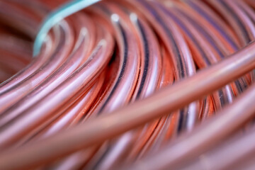 Close-up of new copper wire wound into a coil. Close-up of coils of copper wire. Copper wire randomly wound into a coil. A detailed shot of copper wires with selective focus