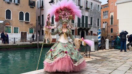 Venice Carnival. People in Venetian carnival masks and costumes on streets of Venice, Italy, Europe...