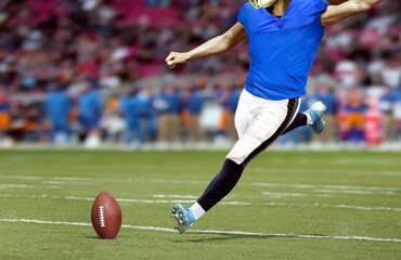 American football player kicking ball during football match
