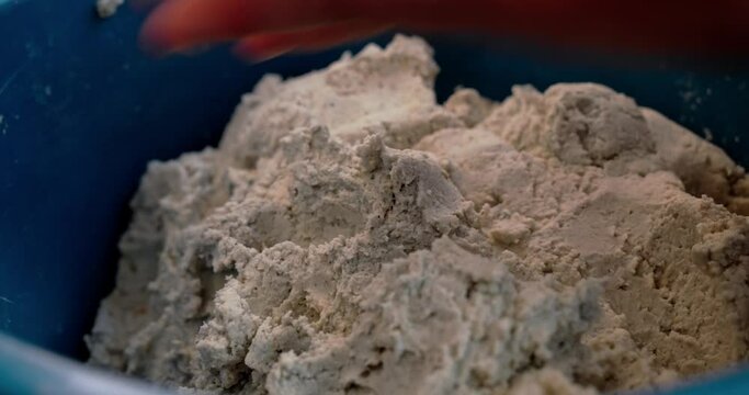 close up of a woman's hands on corn dough for making tortillas, traditional mexican food. home cooking and authentic mexican gastronomy.
