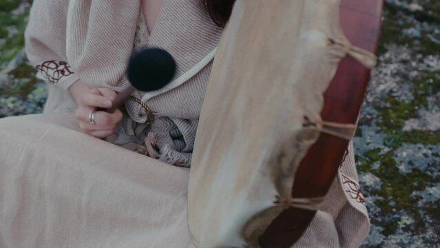 spiritual woman playing a shamanic drum medium detail shot