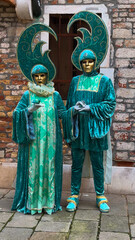 Venice Carnival. People in Venetian carnival masks and costumes on streets of Venice, Italy, Europe...