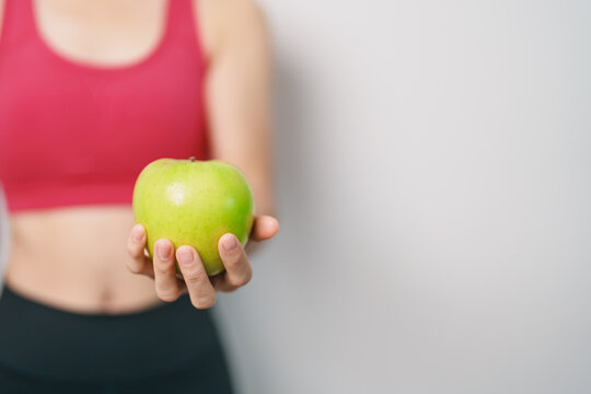 woman hand hold green Apple, happy female fitness choose fruit is Healthy food. Dieting control, Weight loss, Obesity, eating lifestyle and nutrition concepts