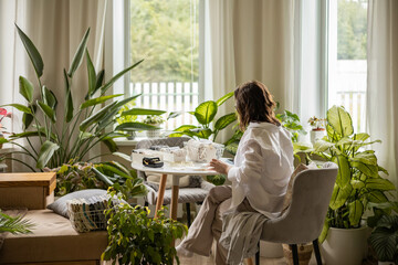 Smiling plus size woman folding linen nightdress in PVC container metal basket storage organizing