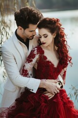 Fototapeta na wymiar Bold Bridal Style Red-Dressed Bride with White Suit Groom