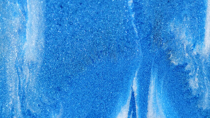 Glitter texture. Shiny particles. Defocused blue white color sparkling shimmering grain paint...