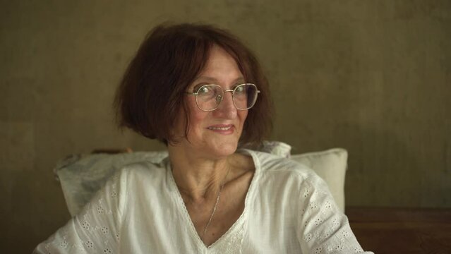 Happy caucasian mature woman have fun, elderly woman looks at the camera with a playful flirtatious good mood look, relish carefree retired life. 4K