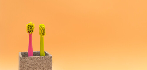 Banner Used Old And New Toothbrush On Peach Yellow Background, Empty Space For Text. Replace Old Toothbrush With A New. Personal Oral Hygiene Set. Old And New Toothbrushes Horizontal Plane