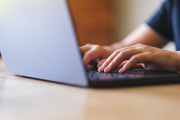 Closeup image of a woman working and typing on laptop computer keyboard