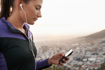 Woman, fitness and earphones with phone for music, podcast or listening to audio on mountain in...