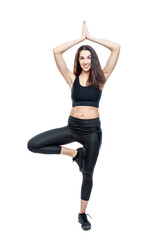 A slender woman in sportswear does exercises. Beautiful brunette in black leggings and top. Health, sports and slimness. Full height. Isolated on a white background. Vertical.