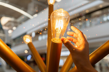 Creative idea with a sparkling light bulb. Change electric light bulbs, energy efficiency. - obrazy, fototapety, plakaty