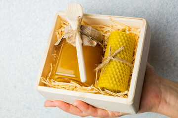 Vitamins and organic products in the gift. Honey in a jar with a stick and wax candles. Gift in a...