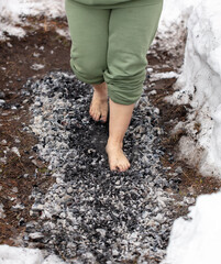 Legs of a girl walking on burning coals