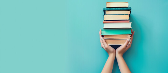 book day concept blue background. hand woman holding pile of book