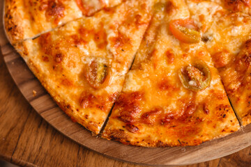 Pizza on a wooden tray top view. Delicious margherita pizza close-up. Appetizing Italian food concept