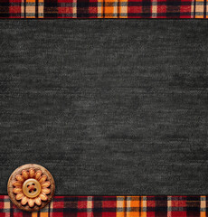 Black denim background with striped borders and decorative button. Dark grey denim jeans fabric...